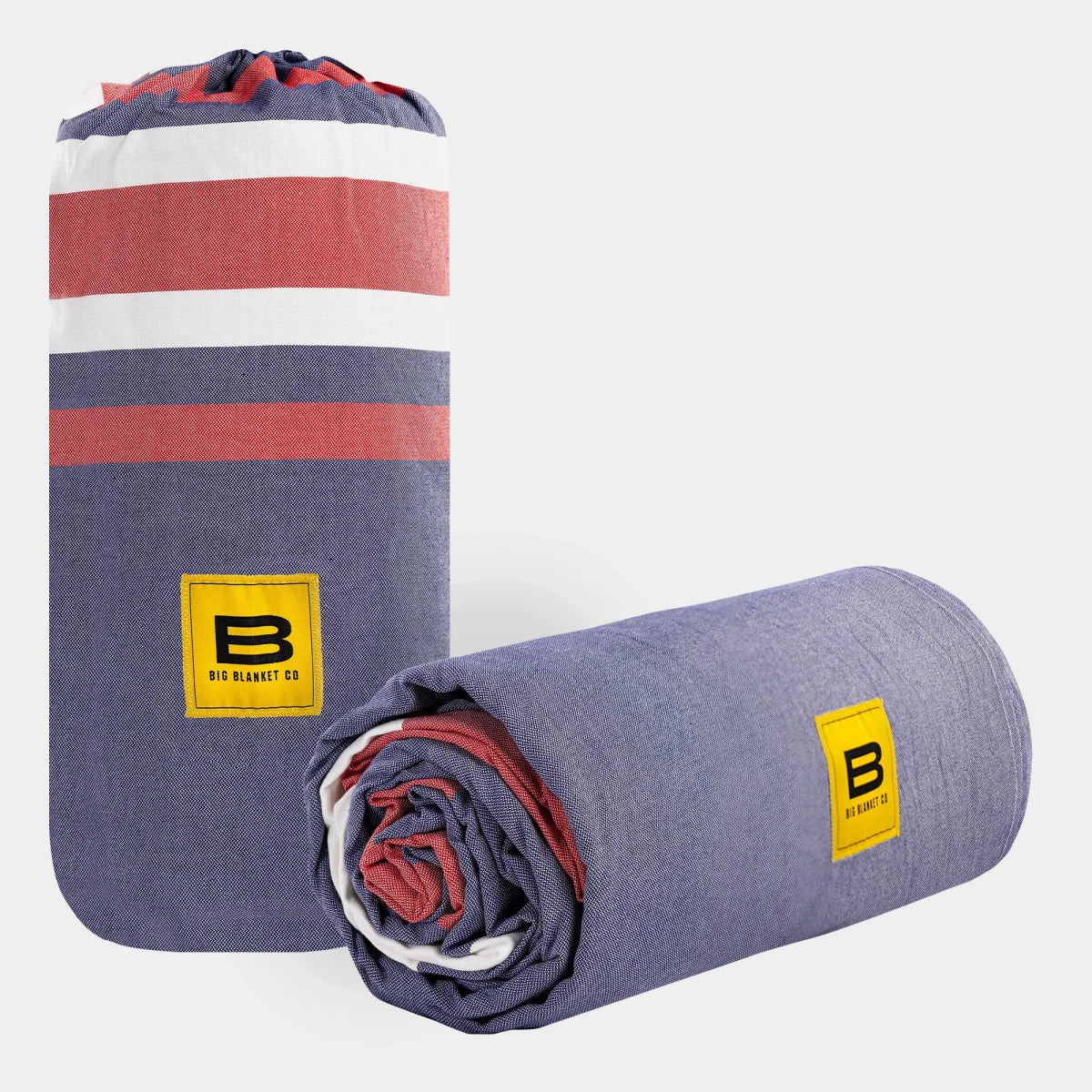Big Beachy oversized blanket in navy, white, and coral stripes, rolled and unrolled display with yellow Big Blanket Co branding