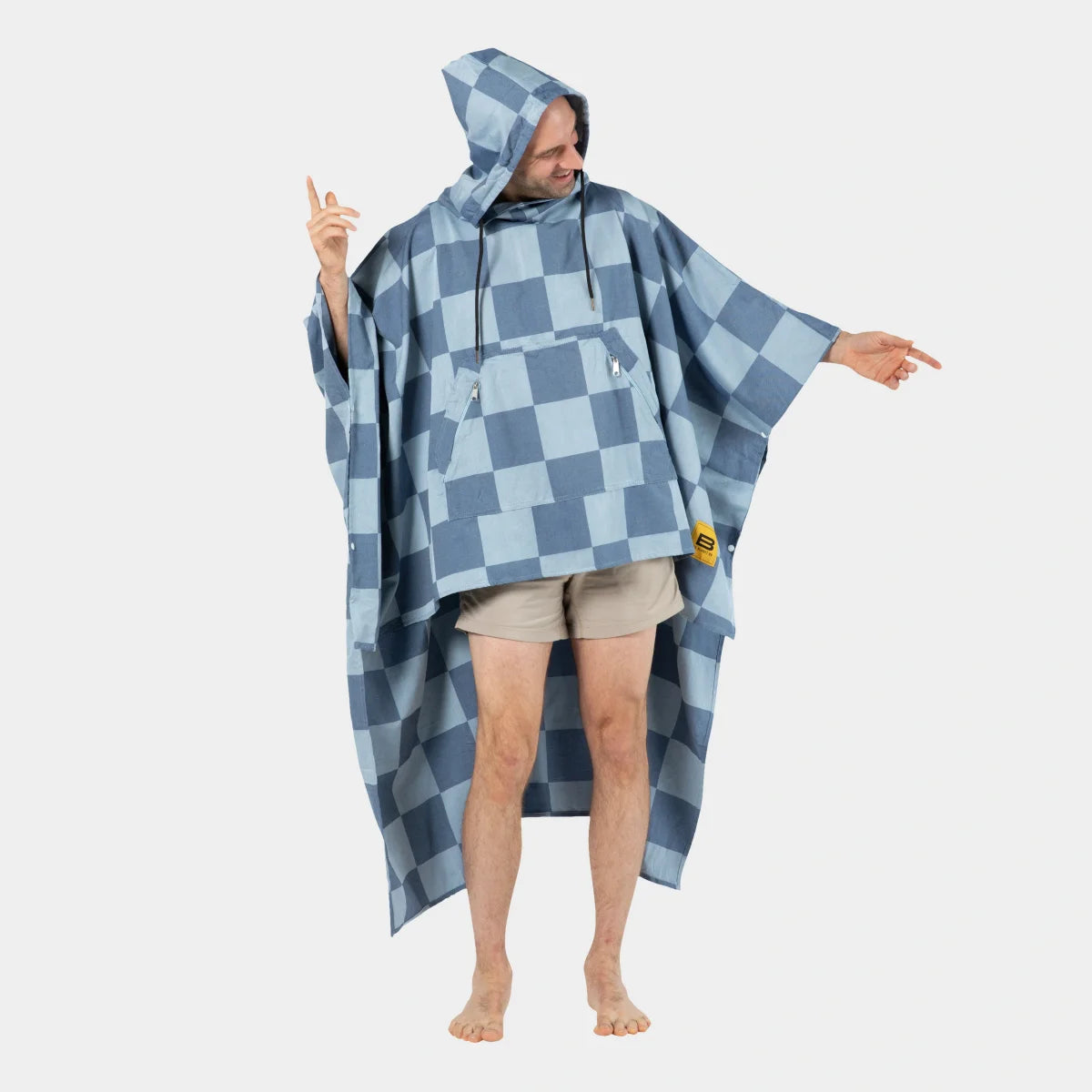 Man wearing blue and light blue checkered oversized poncho blanket with hood over casual clothes