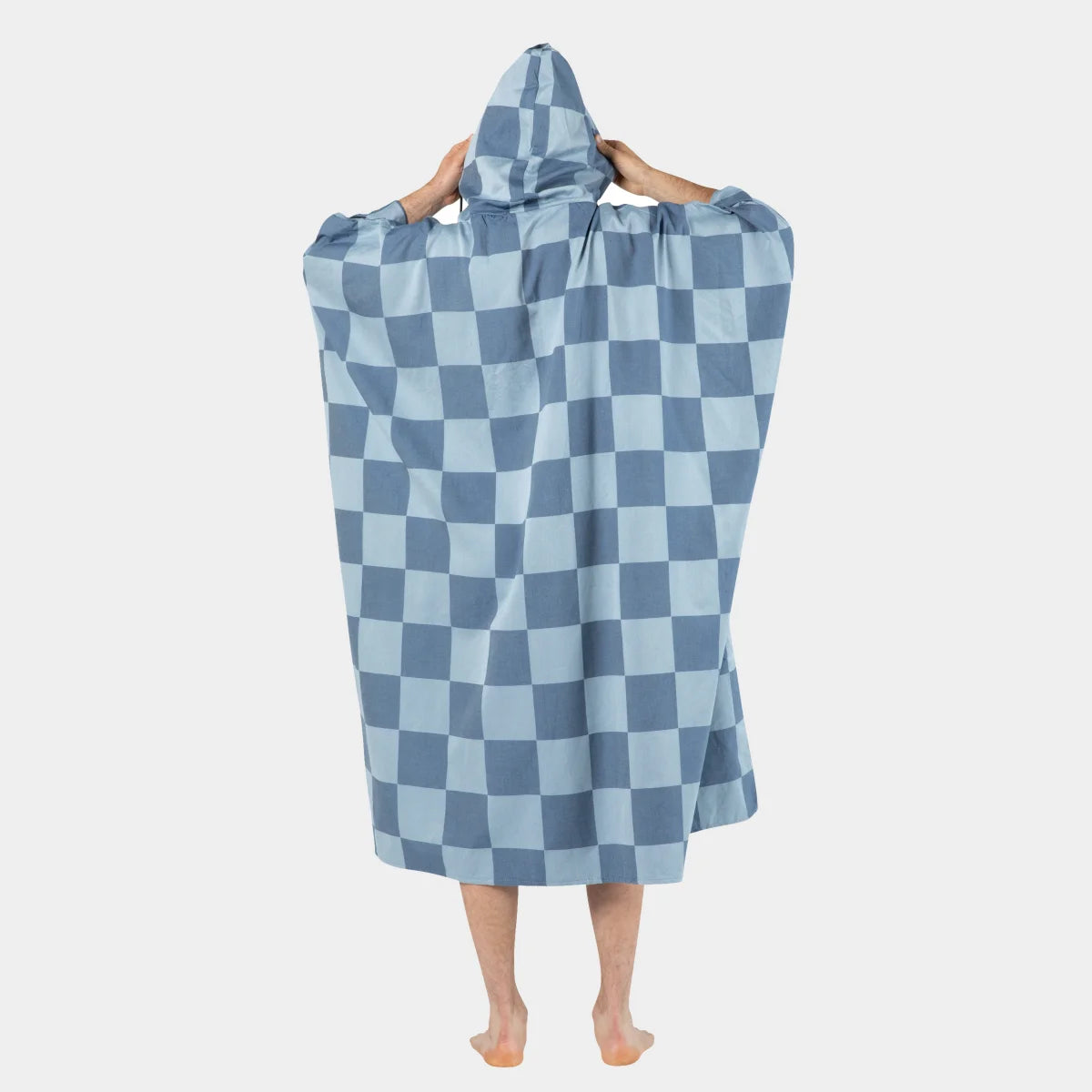 Blue and light blue checkered oversized poncho with hood worn by person from behind, showing full coverage and drape