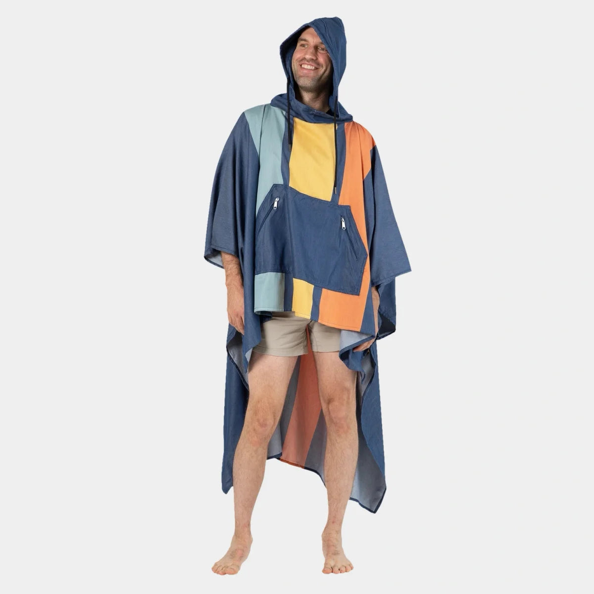 Man wearing oversized hooded beach poncho with navy, light blue, yellow, and orange color blocks