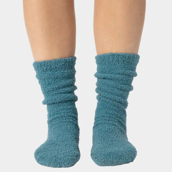 Teal fuzzy crew socks with gathered texture, worn on feet against white background