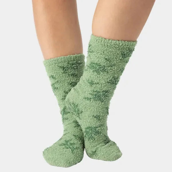 Sage green fuzzy cozy socks worn on feet, showing plush texture and comfort fit