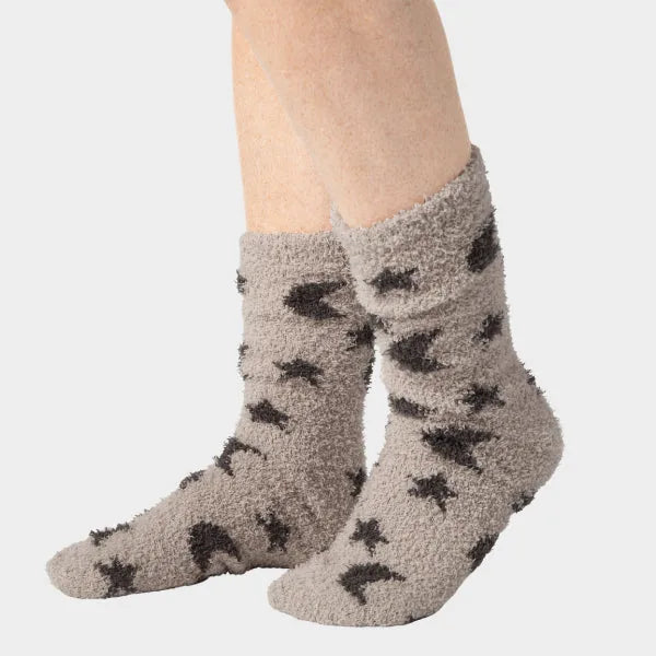 Gray fuzzy socks with black star pattern, shown on feet against white background