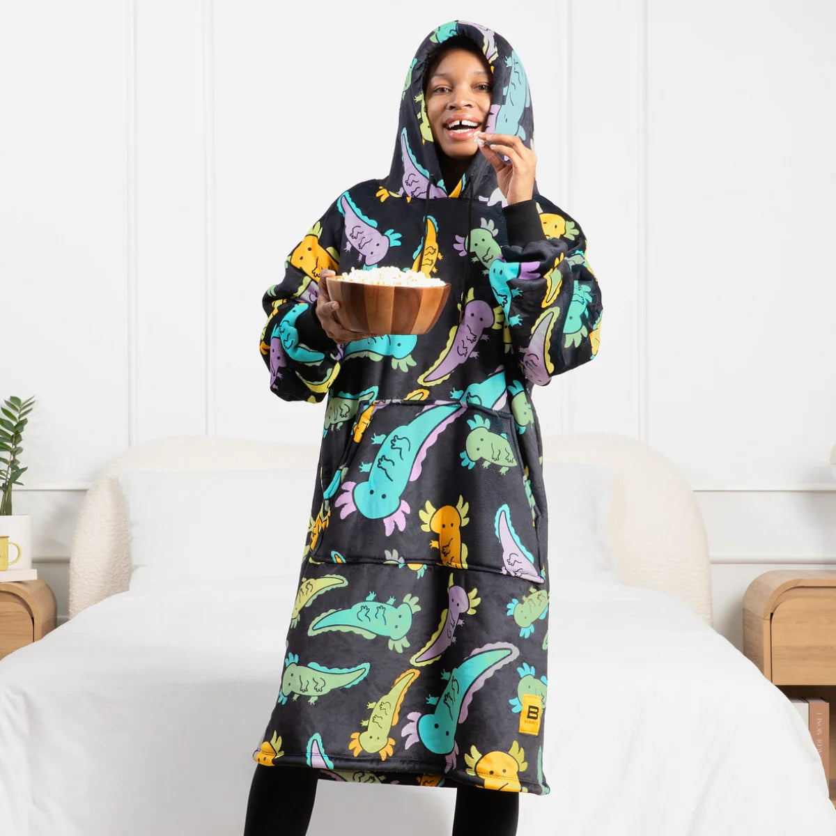 Person wearing the Axolotl Drift Hideout Hoodie™ and holding a bowl of popcorn