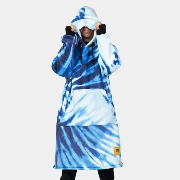 Man wearing blue and white tie-dye Hideout Hoodie oversized blanket with hood pulled up and matching cap