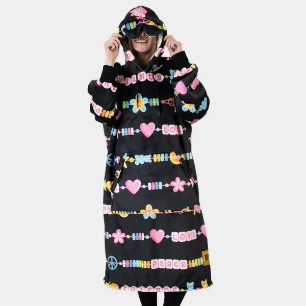 Black oversized hoodie blanket with colorful beaded graphic stripes, pink flowers, hearts, and peace symbols