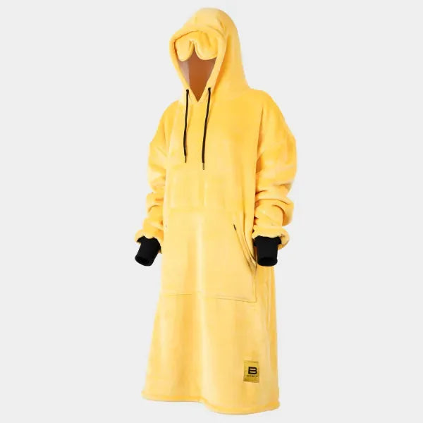 Bright yellow oversized hoodie blanket with black cuff accents and front pocket, worn by model with hood up