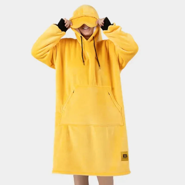 Bright yellow oversized hoodie blanket with kangaroo pocket and adjustable hood, worn with matching visor