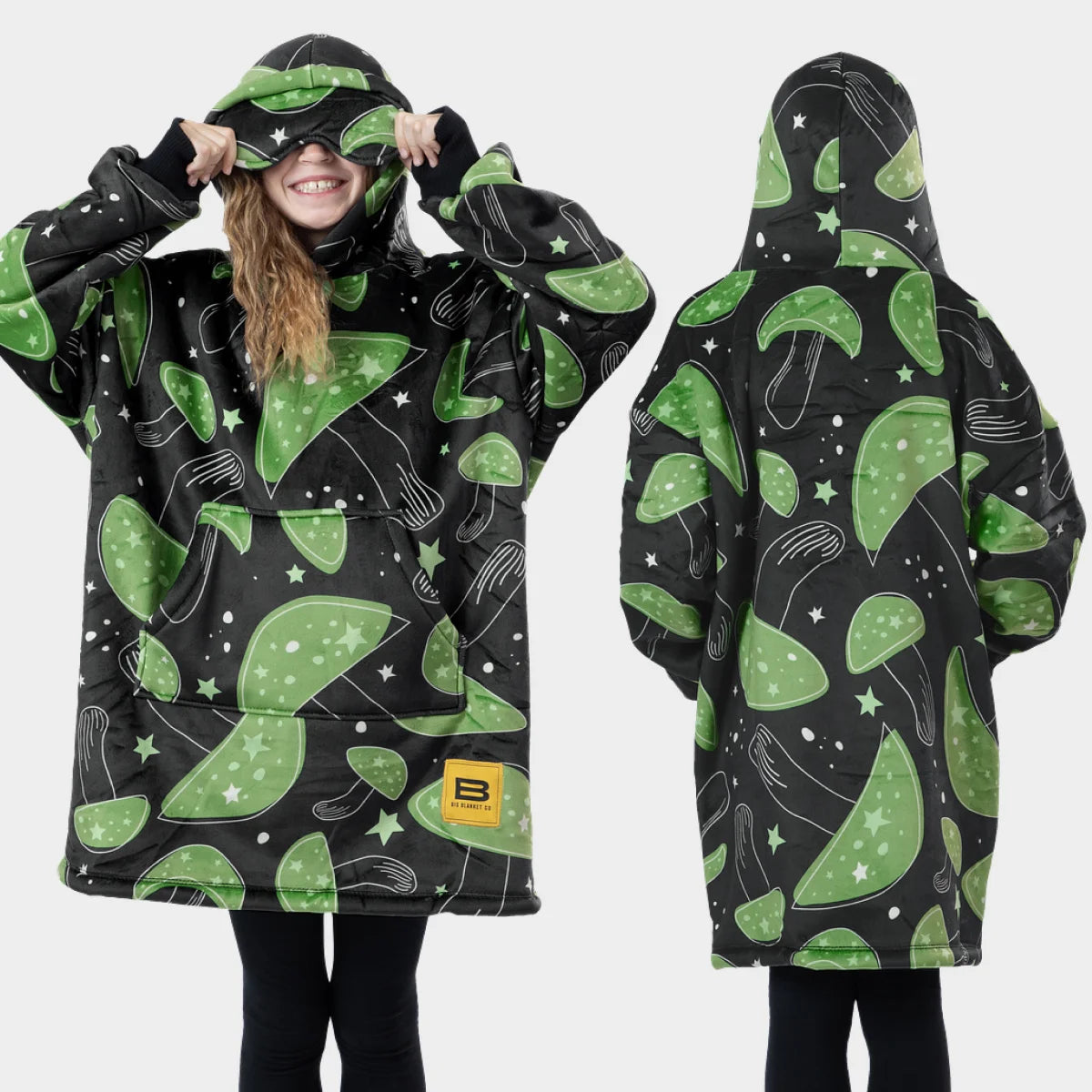 Front and back views of the Mystic Mushrooms Hideout Hoodie™ Kids, with a child lifting the built-in eye mask off their eyes