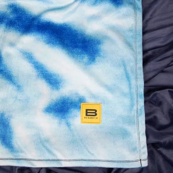 Blue tie-dye oversized blanket with yellow Big Blanket Co label detail