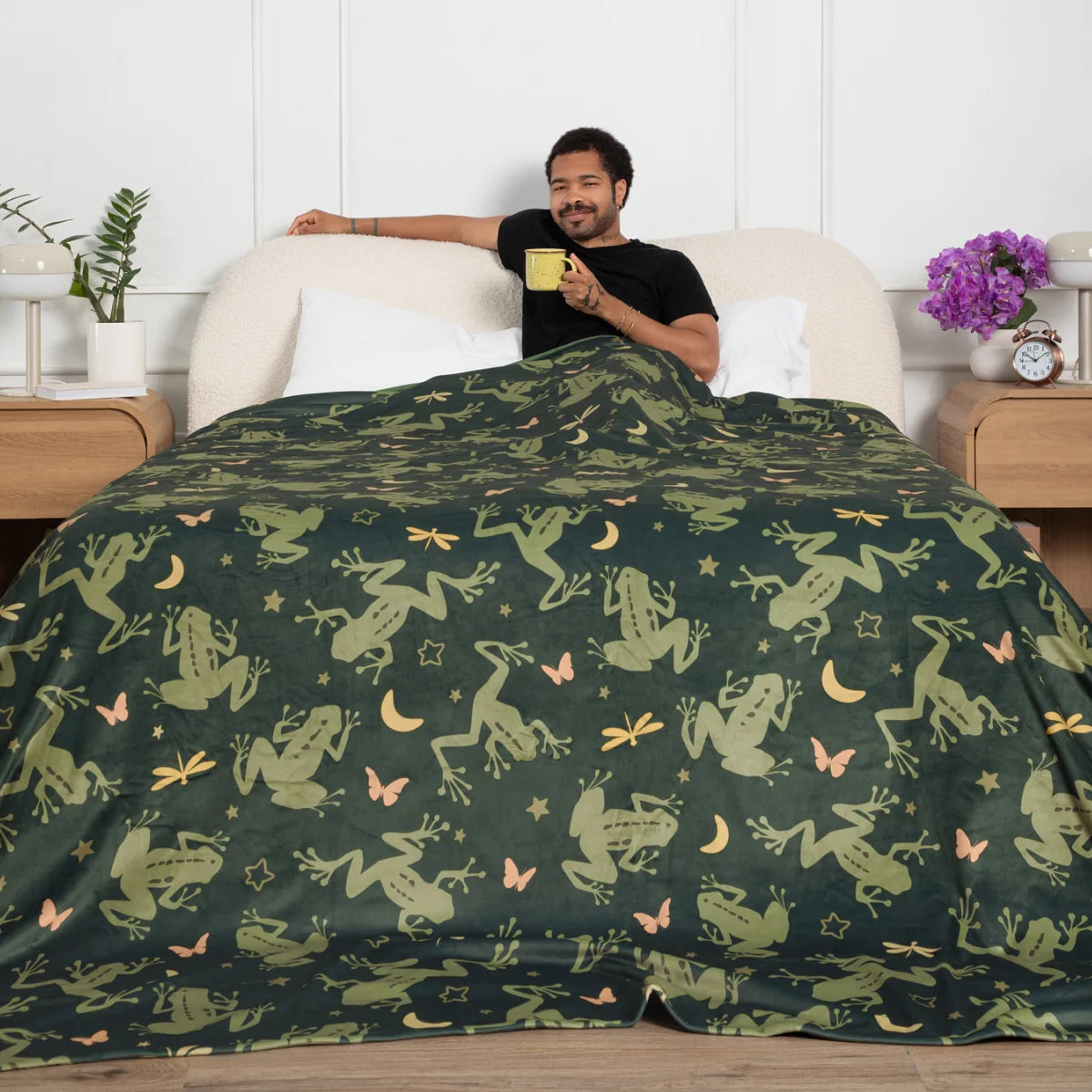 Person sitting up in bed wrapped in the Dreamy Frogs Original Stretch™ oversized blanket