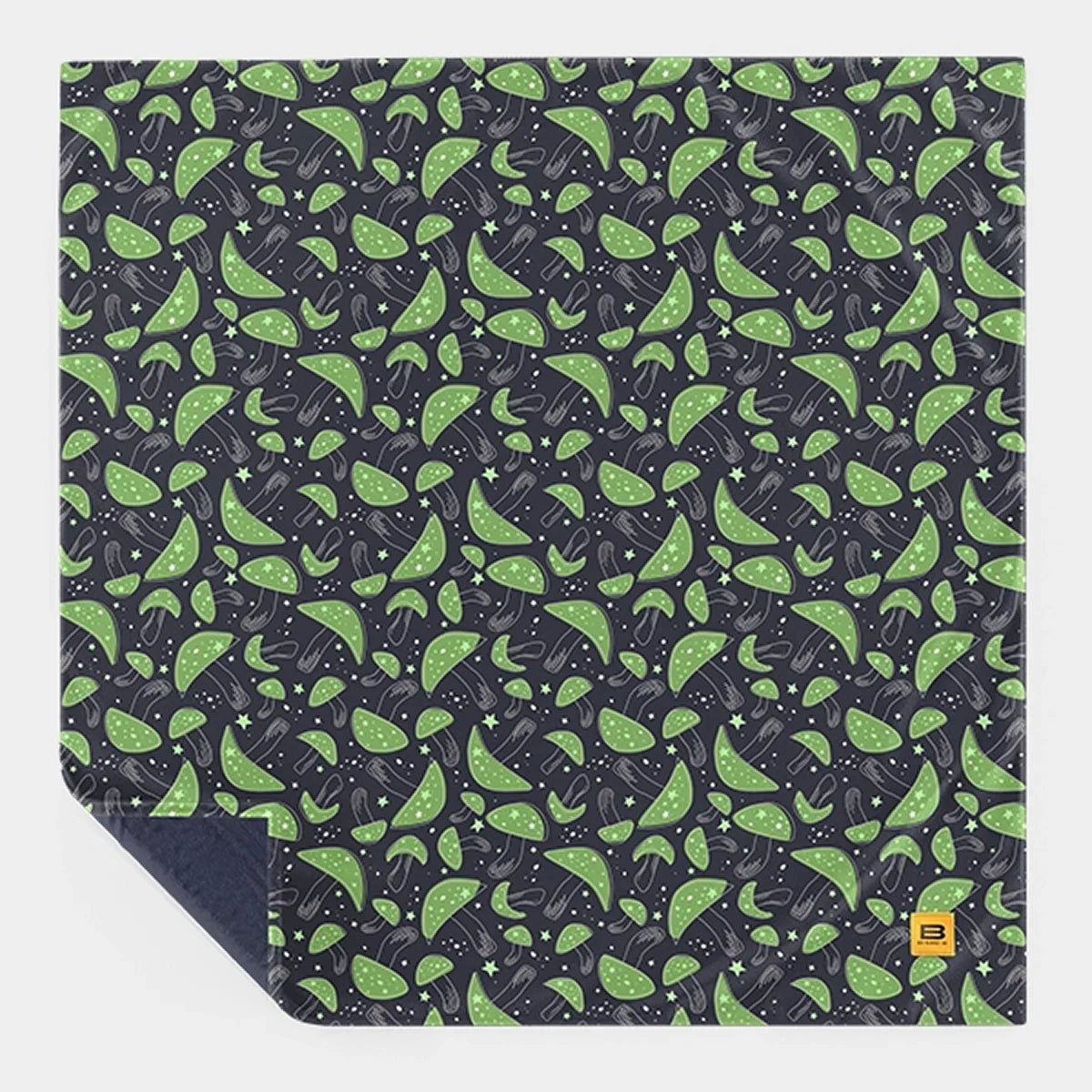 Mystic Mushrooms Original Stretch™ blanket laid flat as a full square with one corner turned back to show the navy reverse