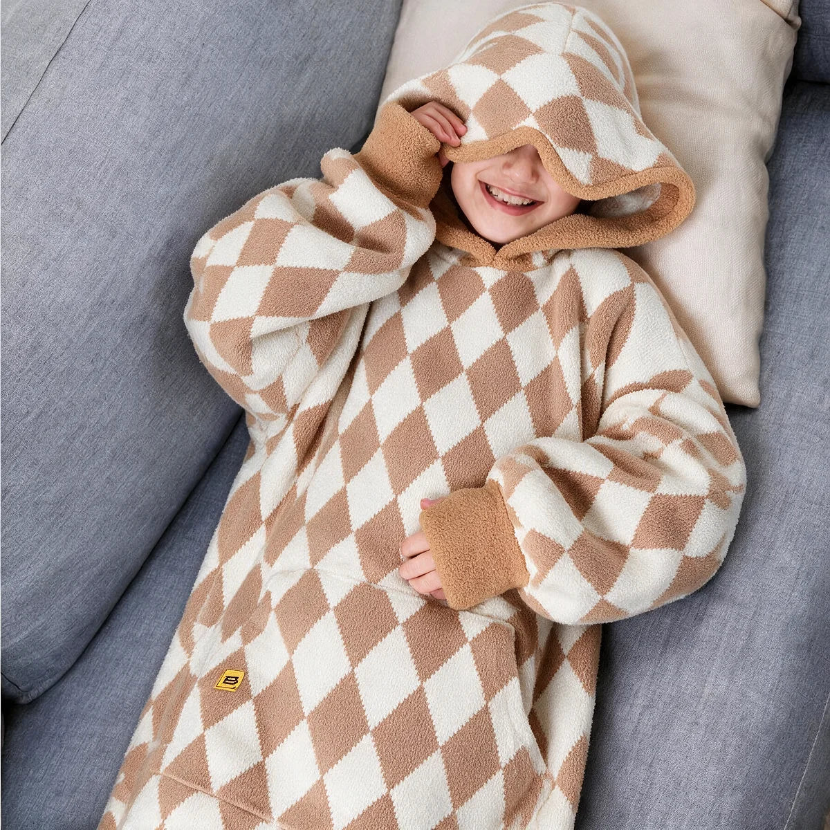 Child resting against a cushion wearing the Dusty Diamond Premier Plush™ Hoodie Kids