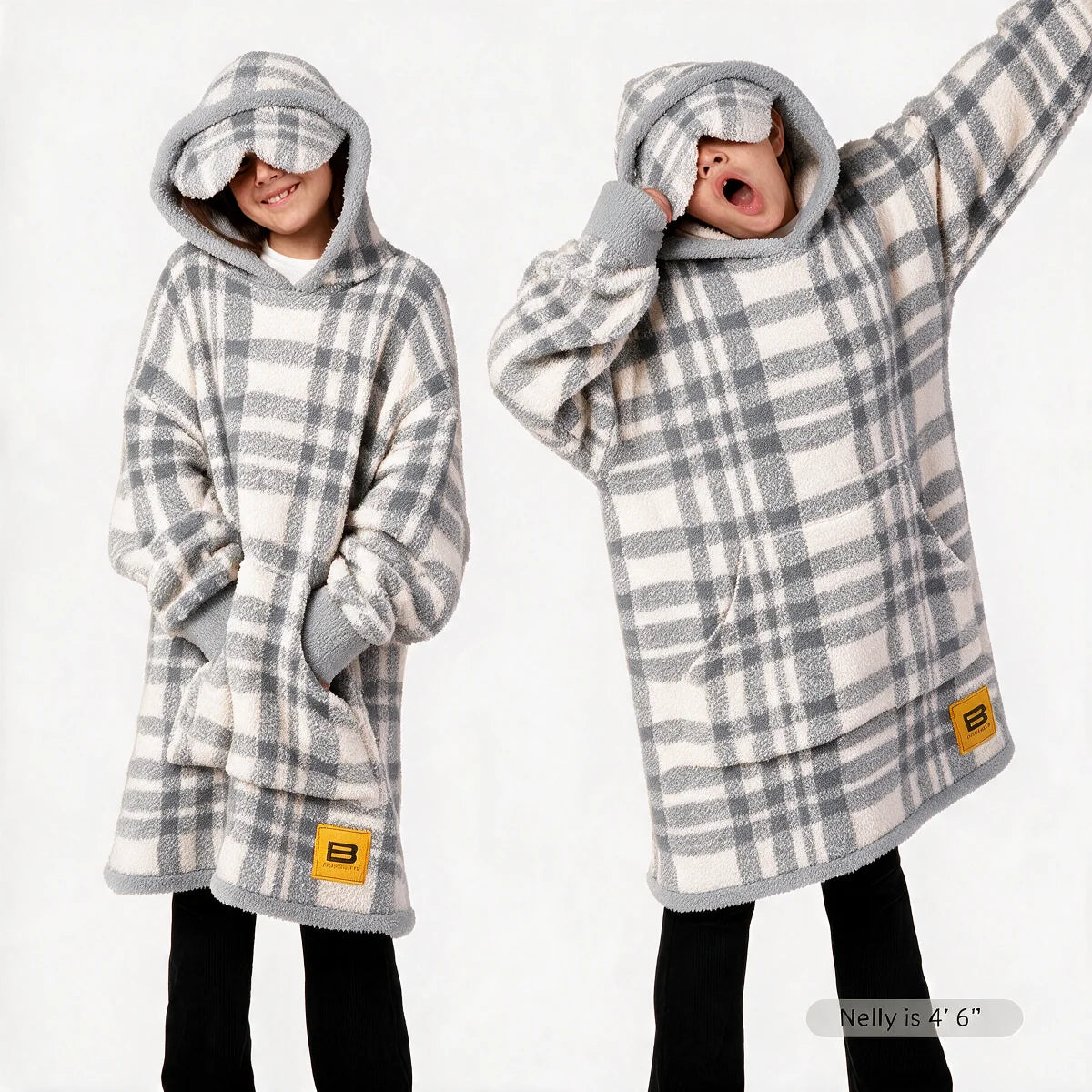 Premier Plush™ Hoodie Kids wearable blanket in Grey Plaid, front and back on two child models — a warm cream ground in a soft neutral grey plaid, with grey edge binding, cuffs and trim