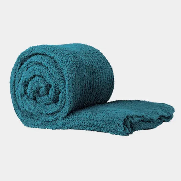 Teal oversized plush blanket rolled and partially unfolded showing soft textured fabric