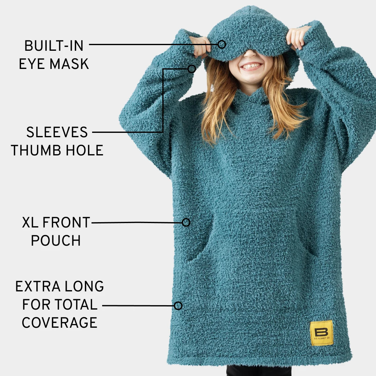 Teal oversized hoodie blanket with built-in eye mask, thumb hole sleeves, XL front pouch, and extra-long coverage on child model
