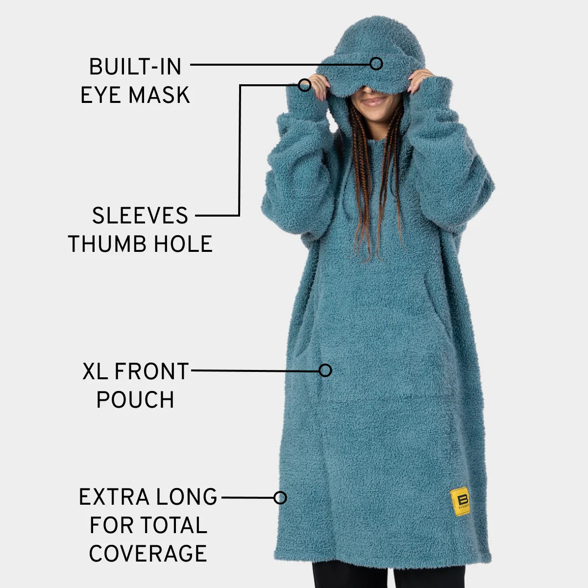 Teal oversized hoodie blanket with built-in eye mask, thumb hole sleeves, and XL front pouch, modeled by smiling person