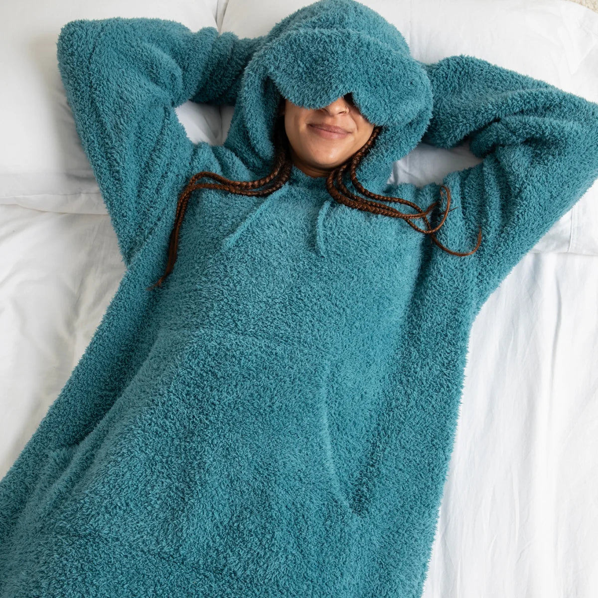 Child wrapped in teal Premier Plush hoodie blanket on gray couch, covering eyes playfully with oversized hood