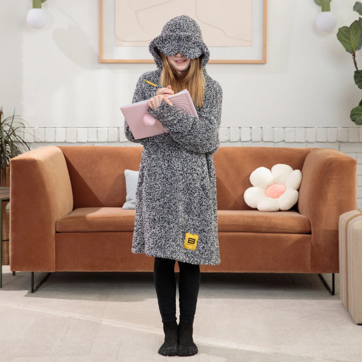 Man wearing gray heather oversized hoodie blanket with kangaroo pocket on bed