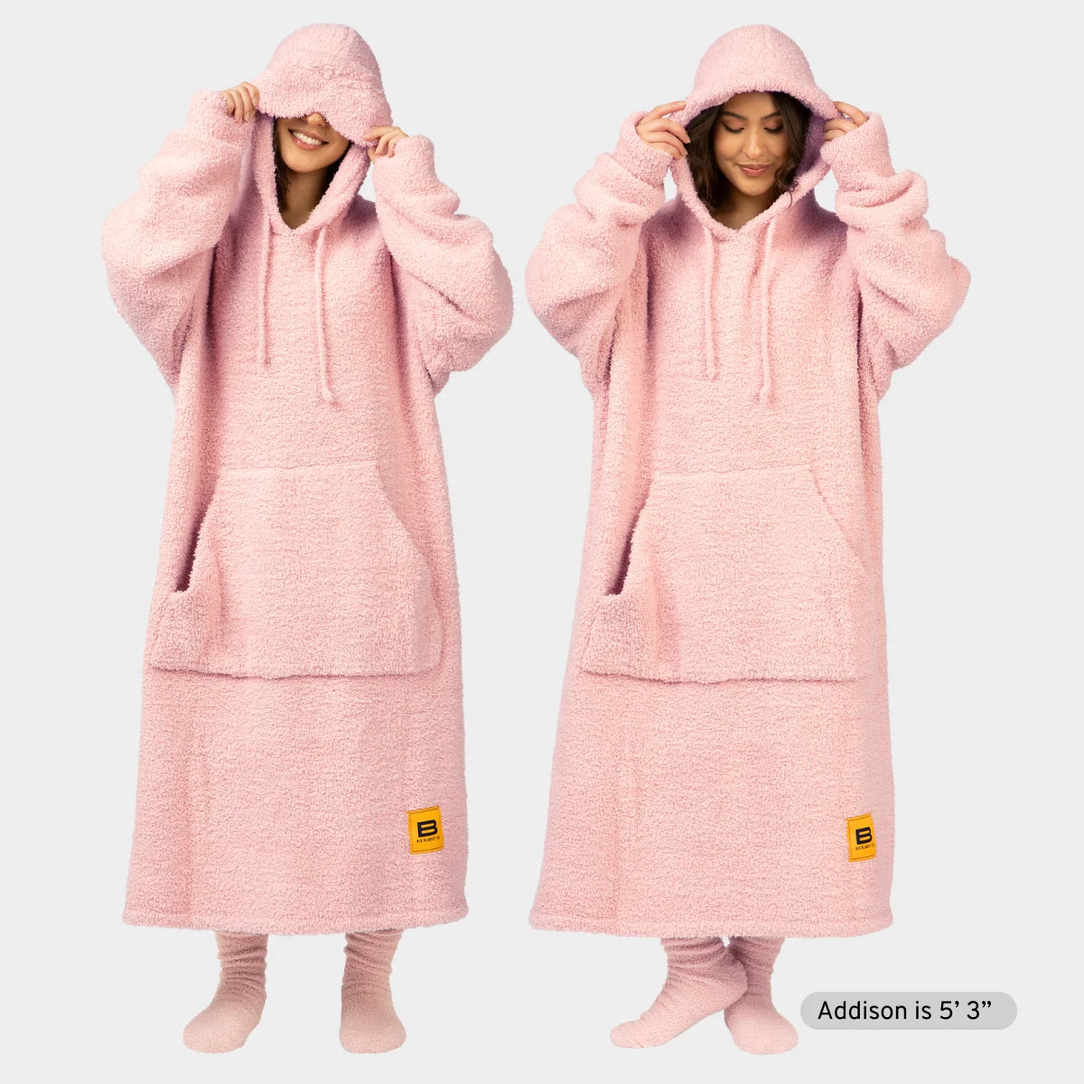 Woman wearing oversized pink fuzzy hoodie blanket with hood up, front kangaroo pocket, shown two ways with matching socks