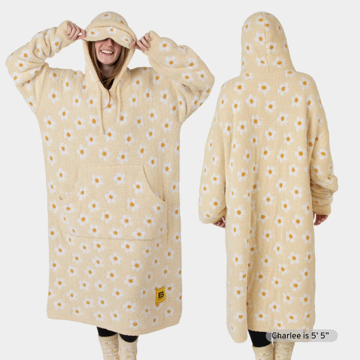 Cream oversized hoodie blanket with yellow daisy pattern, front and back view, worn by model with hood up