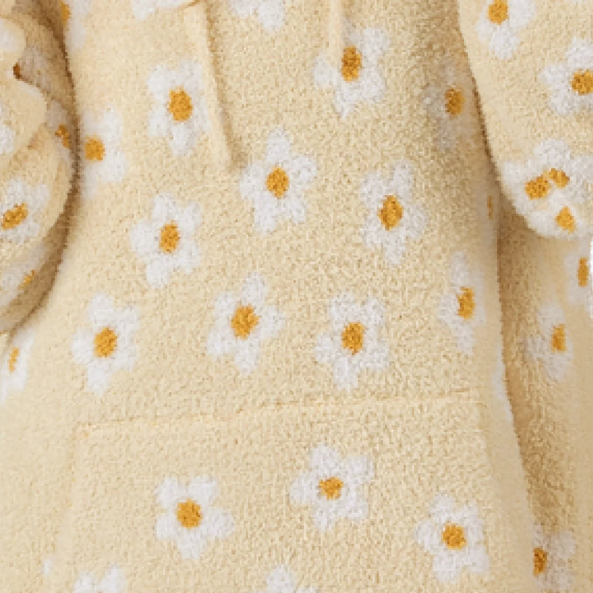 Cream oversized blanket hoodie with yellow and white daisy pattern, soft textured fabric draped in folds