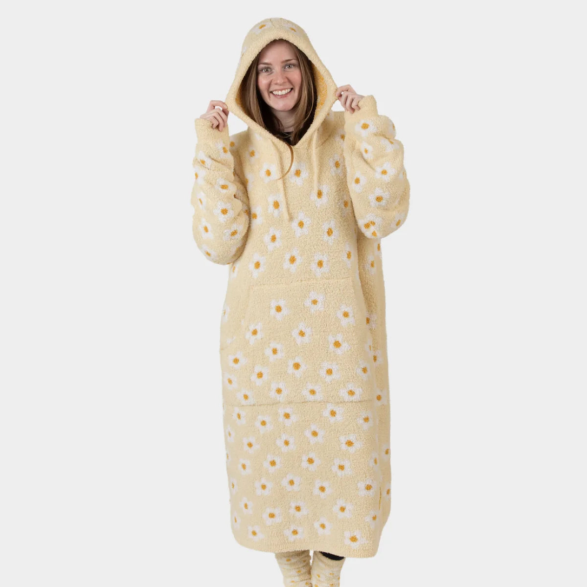 Woman wearing cream Premier Plush Hoodie with yellow daisy print and attached hood, oversized wearable blanket design