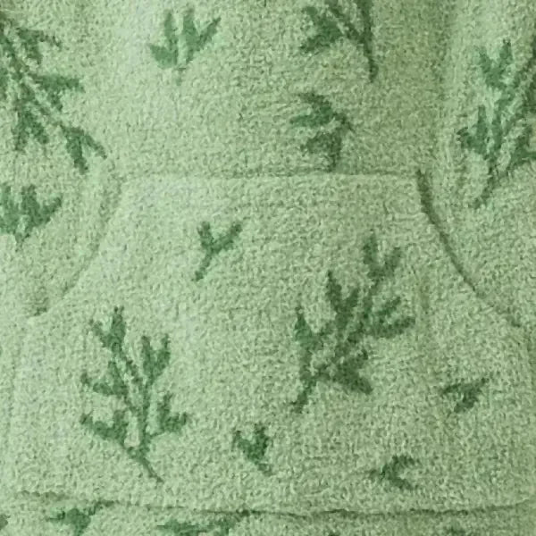 Soft sage green oversized blanket with dark green scattered pine tree pattern, cozy knit texture