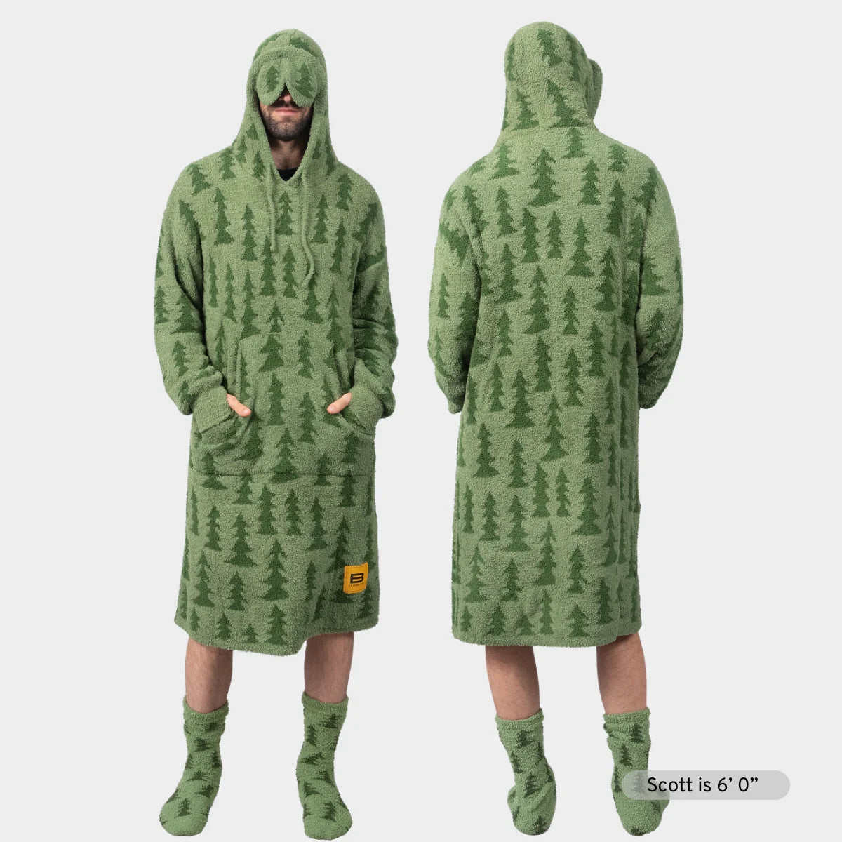 Sage green oversized hoodie blanket with pine tree pattern, front and back view, worn with matching socks