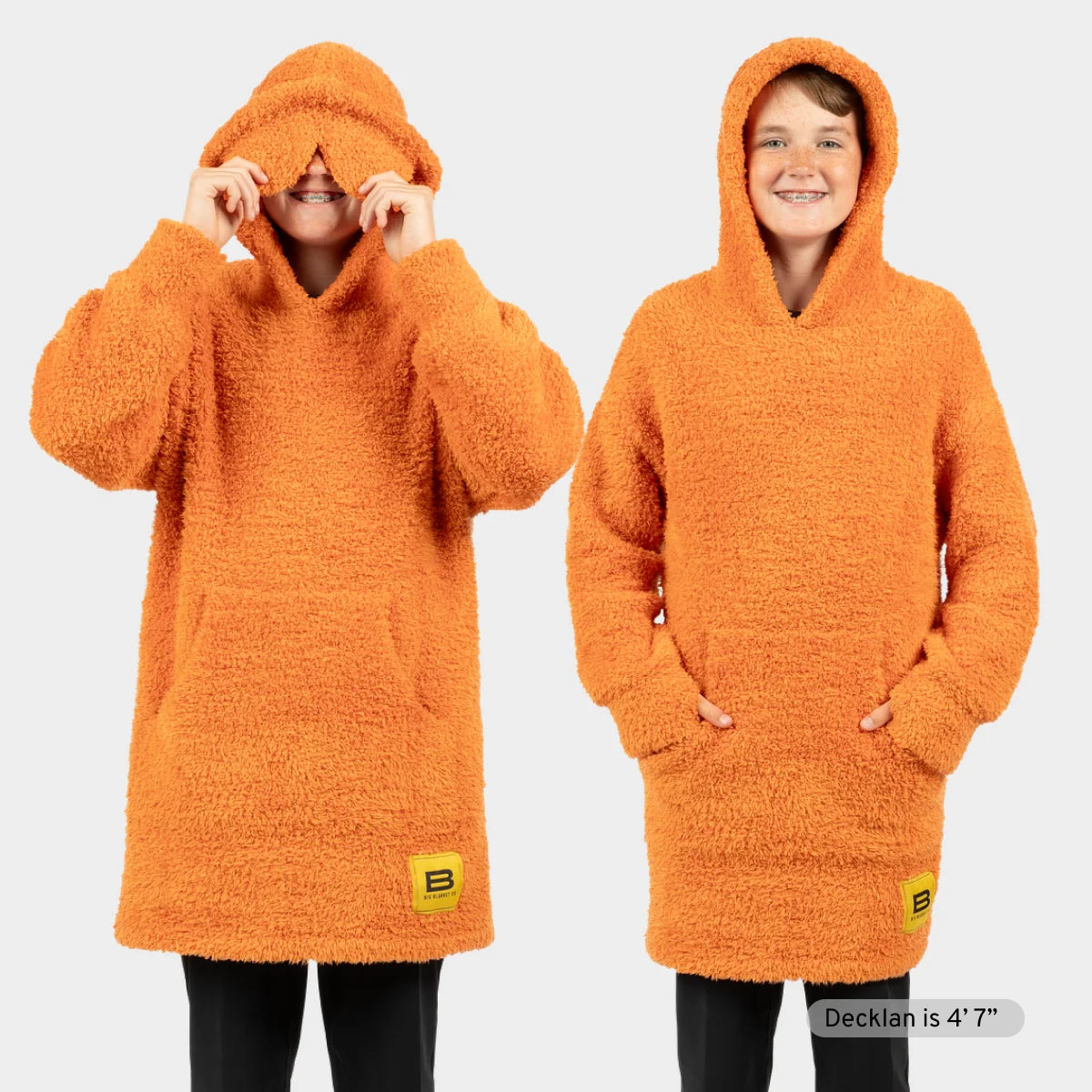 Bright orange Premier Plush hoodie blanket worn by two men showing hood and oversized fit extending to ankles