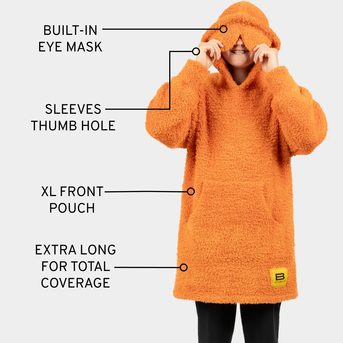 Orange oversized hoodie blanket with built-in eye mask, sleeve thumb holes, XL front pouch, and extra-long length for total coverage