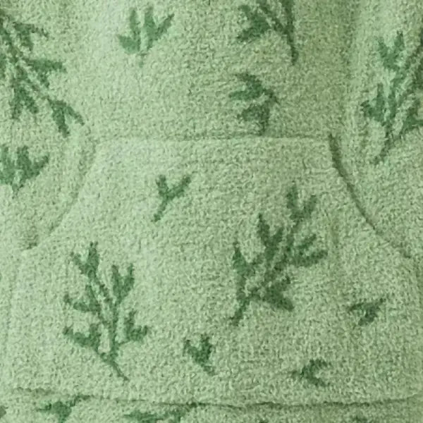 Sage green oversized blanket with fern leaf jacquard pattern, soft plush texture