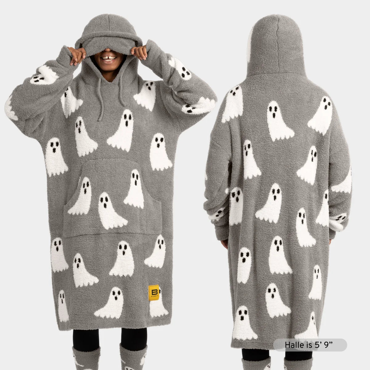 Gray oversized hoodie blanket with white ghost pattern and black eyes, shown front and back on model