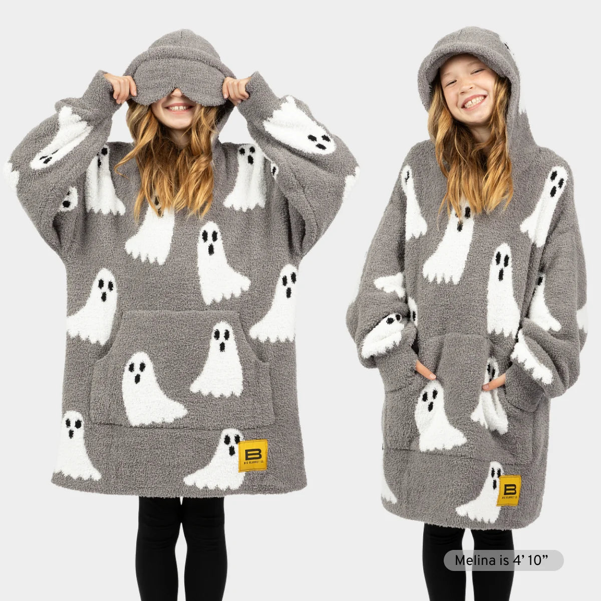 Gray Premier Plush hoodie blanket with white ghost pattern and black eyes, front and back view on child model