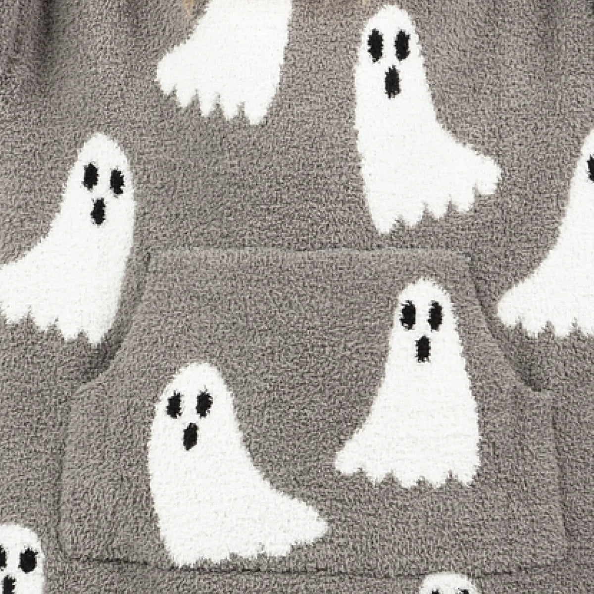 Gray oversized blanket with white ghost faces and black eye details scattered throughout