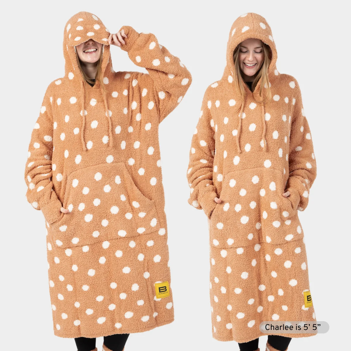 Tan oversized hoodie blanket with white polka dots, shown front and back on child model, features deep kangaroo pocket and drawstring hood