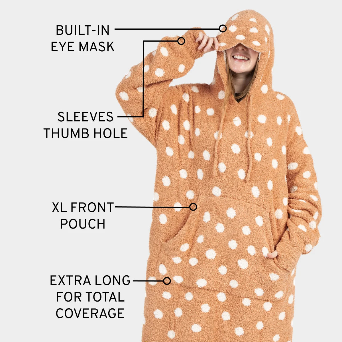Tan oversized wearable blanket hoodie with white polka dots, built-in eye mask, sleeve thumb holes, and XL front pouch