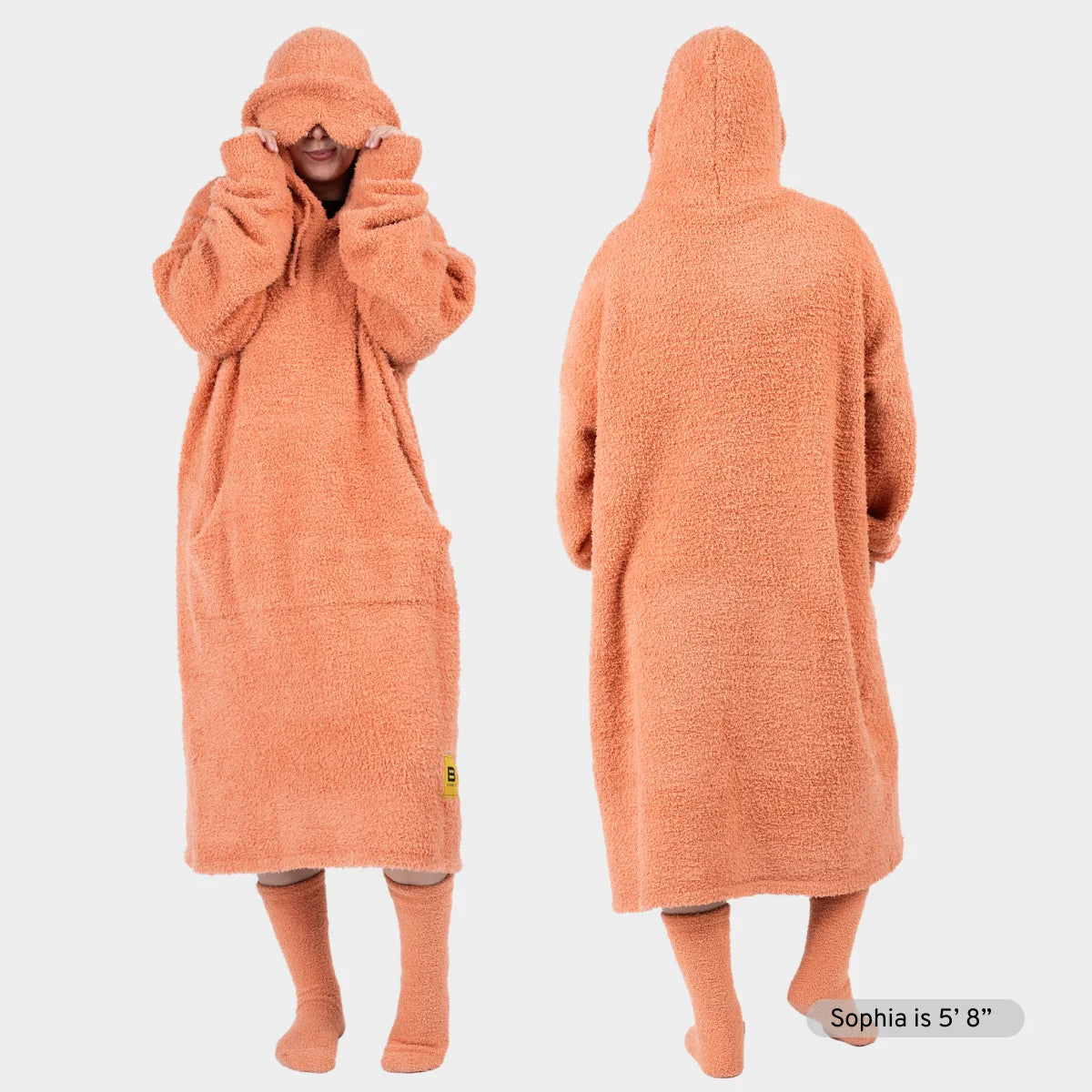 Coral oversized hoodie blanket worn front and back, with matching hood and socks, shown on model
