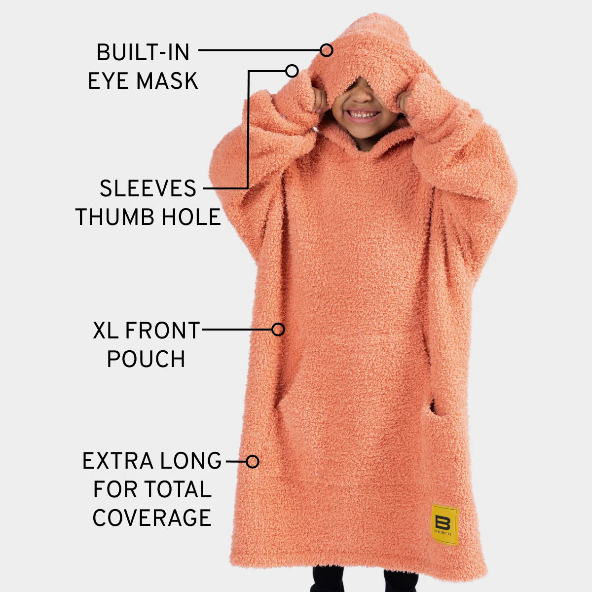 Coral oversized hoodie blanket with built-in eye mask, thumb hole sleeves, and extra-long coverage for kids