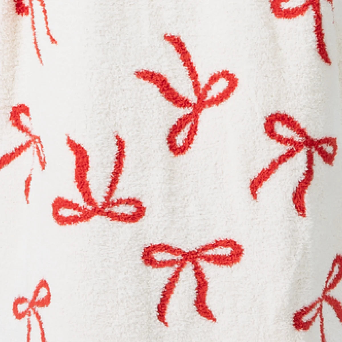 Cream oversized blanket with red bow pattern, soft plush texture