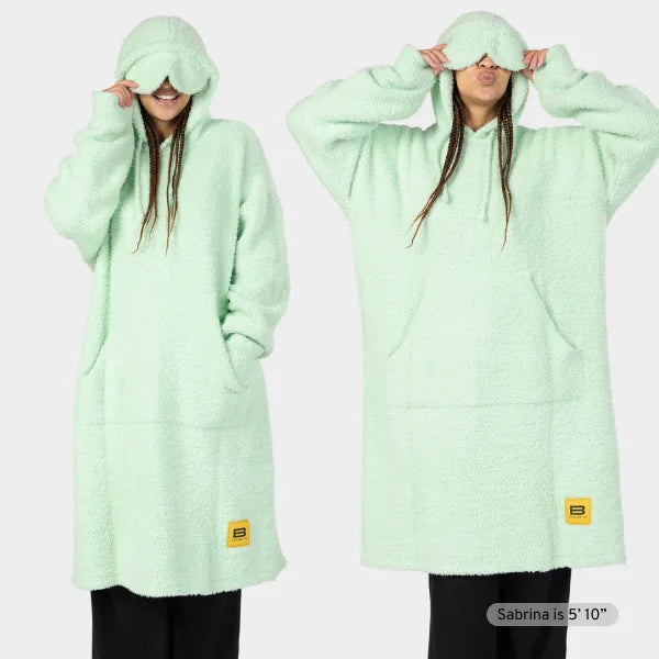 Mint green oversized hoodie blanket with kangaroo pocket and plush texture, shown front and back on model