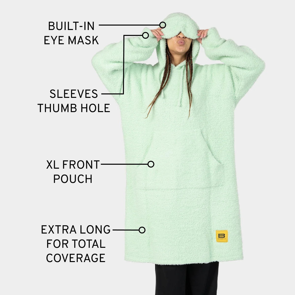Mint green oversized hoodie blanket with built-in eye mask, sleeves with thumb holes, XL front pouch, and extra-long coverage