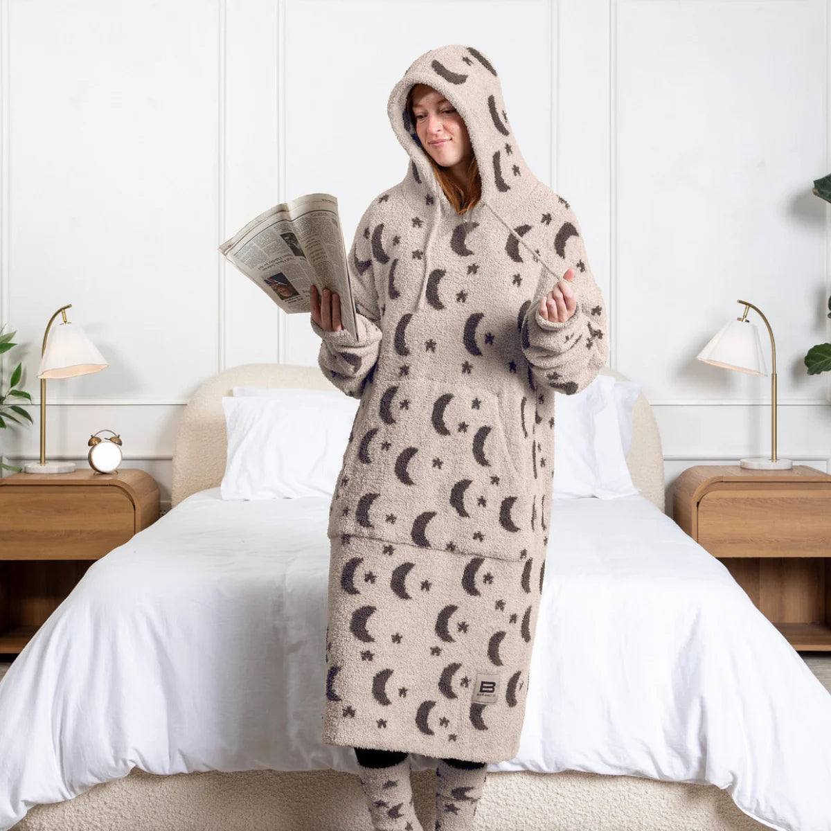 Cream oversized blanket with charcoal moon and star pattern, folded showing plush texture