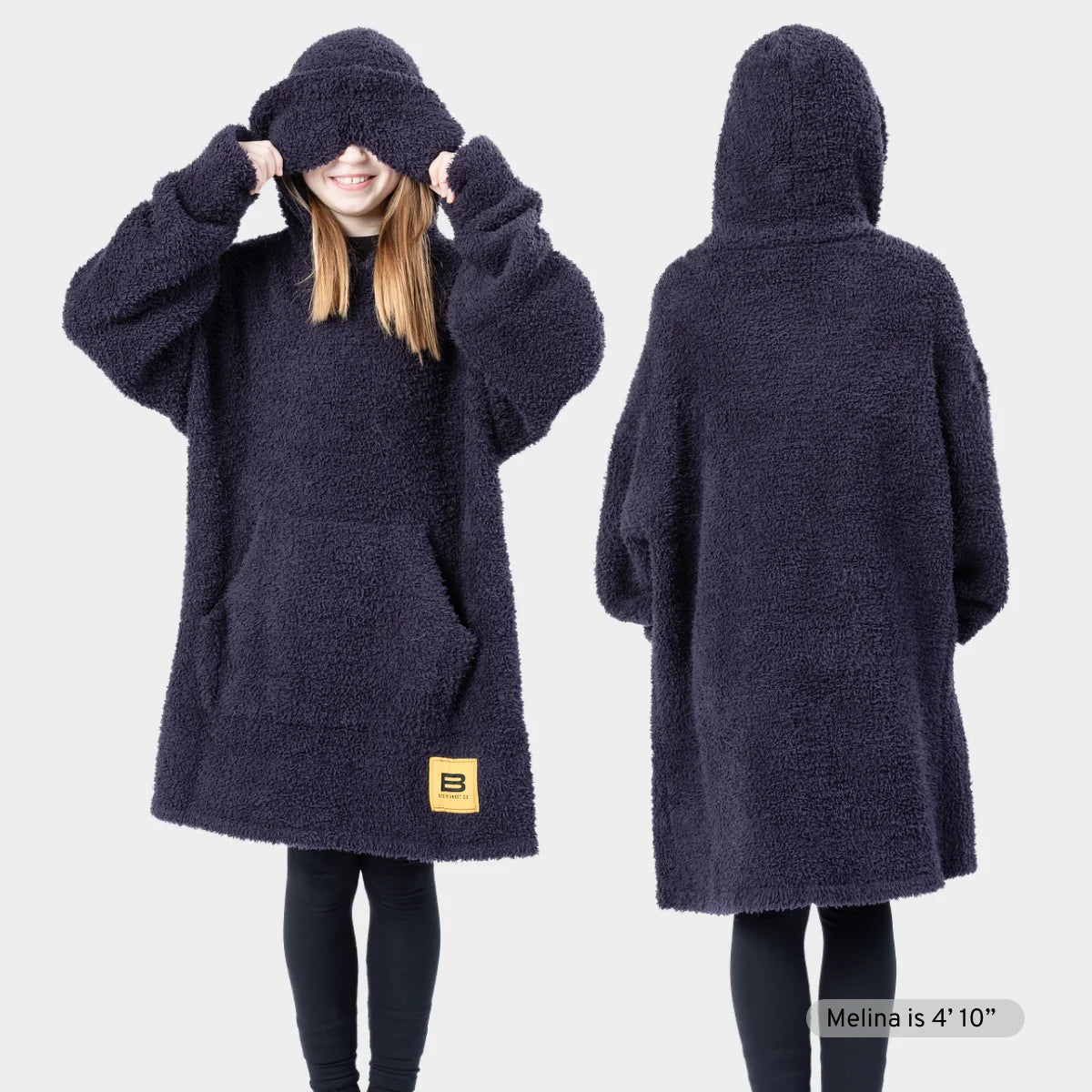 Two people wearing navy Premier Plush hoodie blankets with oversized hoods and kangaroo pockets, demonstrating fit and comfort