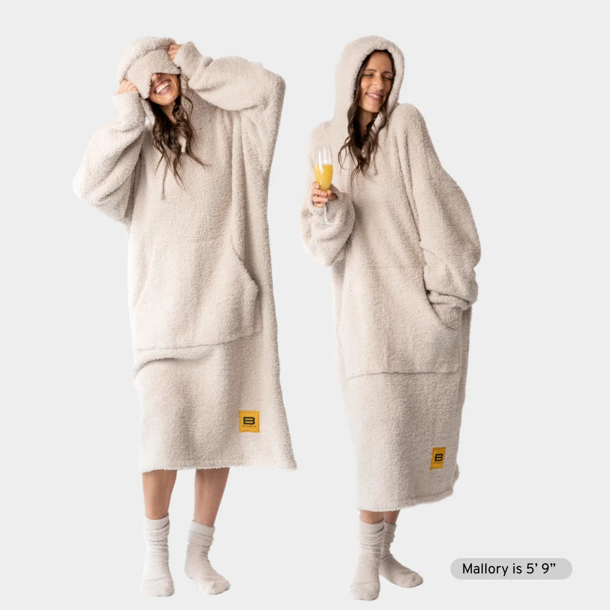 Woman wearing oversized cream hoodie blanket with hood pulled up, shown front and side view with full coverage to ankles