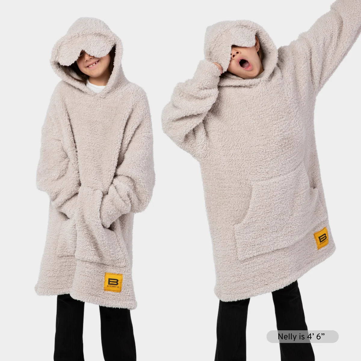 Woman wearing cream oversized hoodie blanket with hood pulled up, holding beverage, shown in two poses demonstrating length and coverage