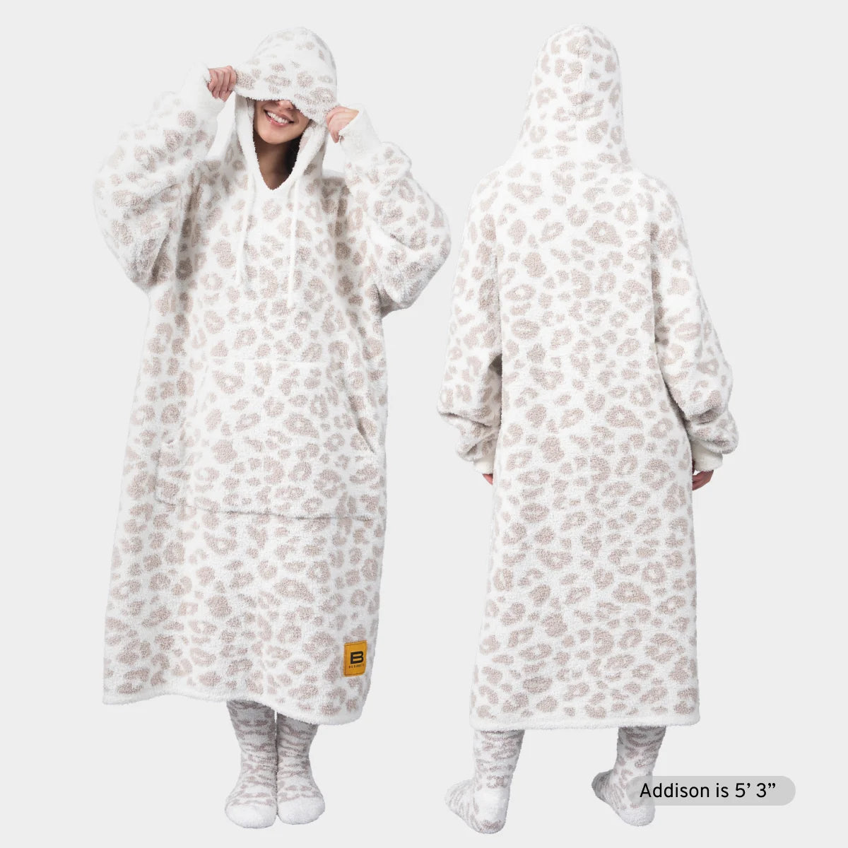 Cream oversized blanket hoodie with snow leopard print worn by smiling woman, front and back view with matching socks