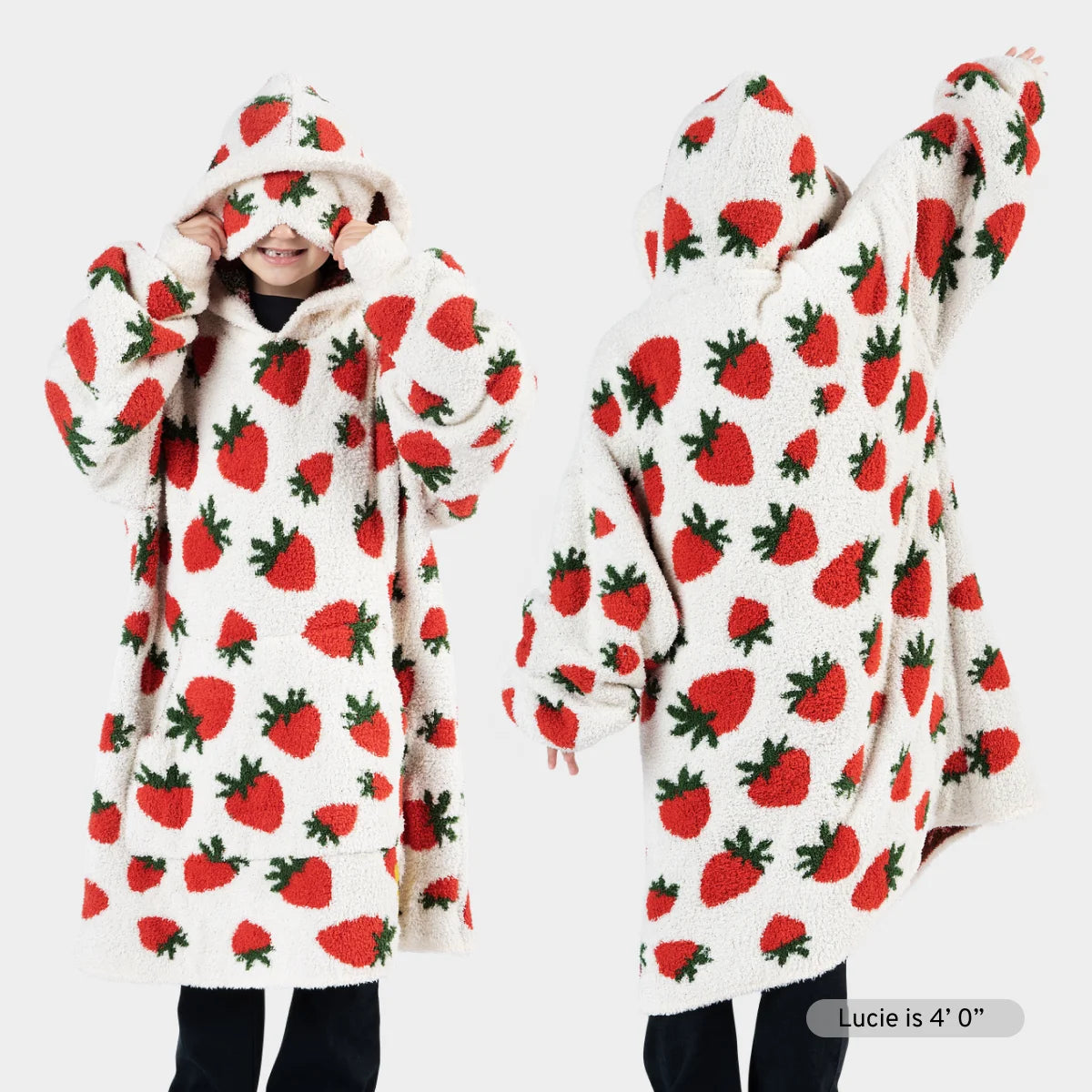 Cream oversized hoodie blanket with red strawberry and green leaf pattern, shown on model from front and back with matching strawberry socks