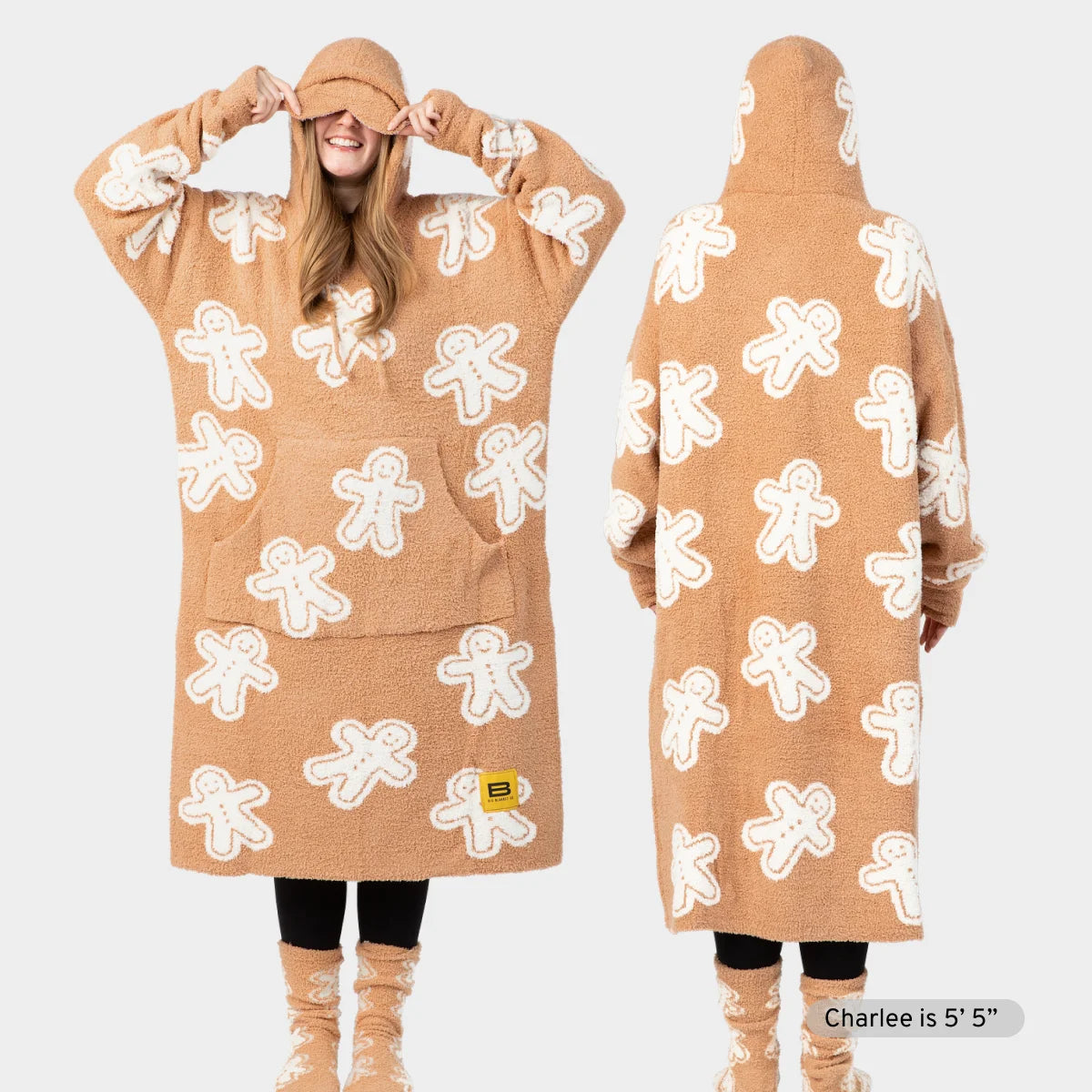 Tan oversized hoodie blanket with white gingerbread man pattern, front and back view on model wearing matching socks
