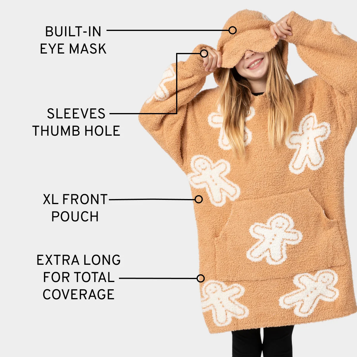 Tan oversized hoodie blanket with white gingerbread man pattern, built-in eye mask, thumb holes, and XL front pouch